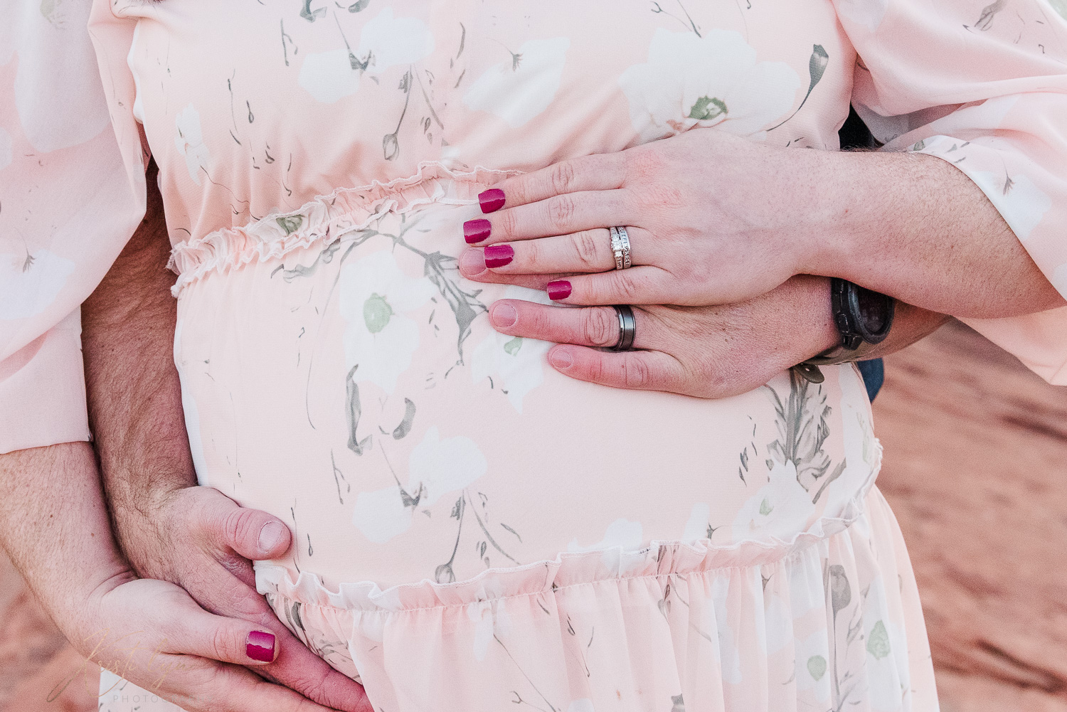 Parents place their hands during maternity session.
